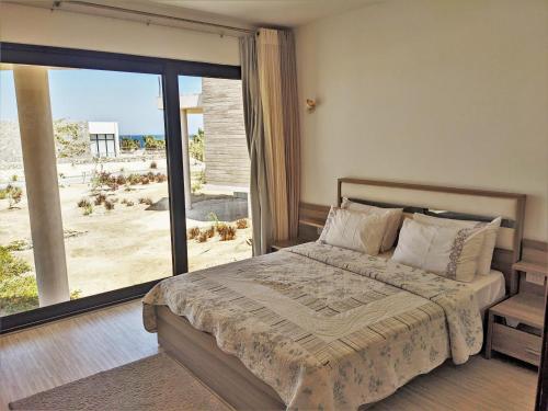 Schlafzimmer mit einem Bett und Strandblick in der Unterkunft Sea View 2BR Villa with Free Beach & Pool in Soma Bay in Hurghada