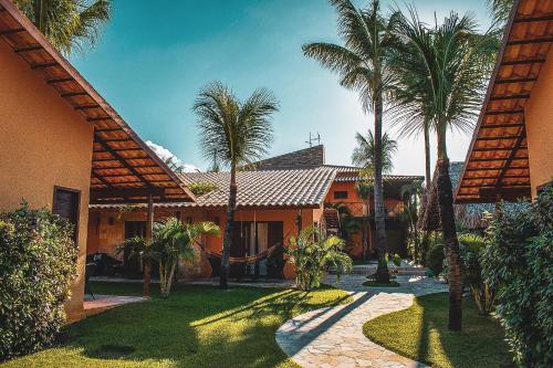 una casa con palmeras delante en Pousada Meeting Point & KiteSchool, en Cumbuco
