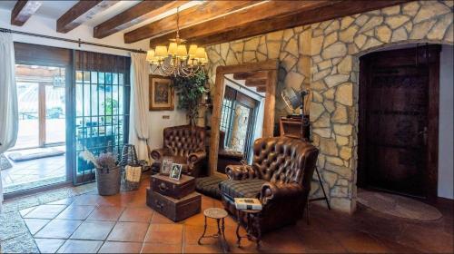 a living room with two chairs and a stone wall at My special Vila in Antequera look in airbnv in Antequera