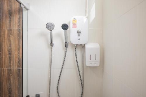 a bathroom with two shower heads on the wall at Picha Ville Resort in Watthana Nakhon