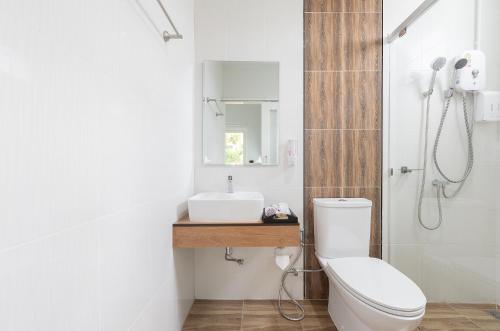 a bathroom with a toilet and a sink at Picha Ville Resort in Watthana Nakhon
