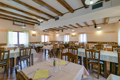 un ristorante con tavoli e sedie con tovaglie bianche di Homestead Vrbin a Divača (Divaccia)