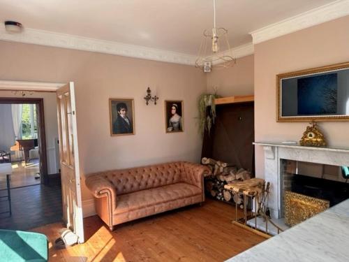 uma sala de estar com um sofá e uma lareira em Walltree House em Brackley