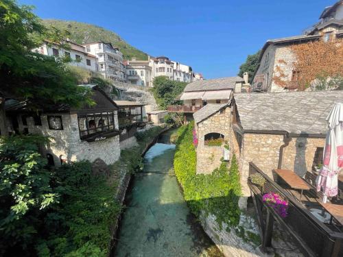 um rio no meio de uma cidade com edifícios em Golden Pearl em Mostar