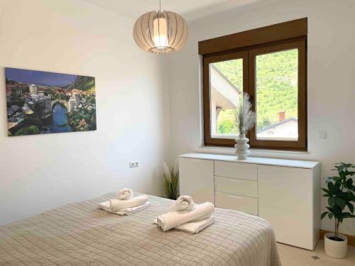 um quarto com duas toalhas numa cama com uma janela em Golden Pearl em Mostar