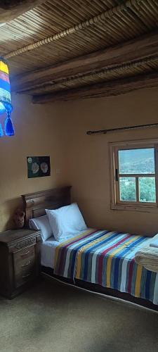 a bedroom with two beds and a window at Ferme Dar Aicha green Bellouta in Bellouta