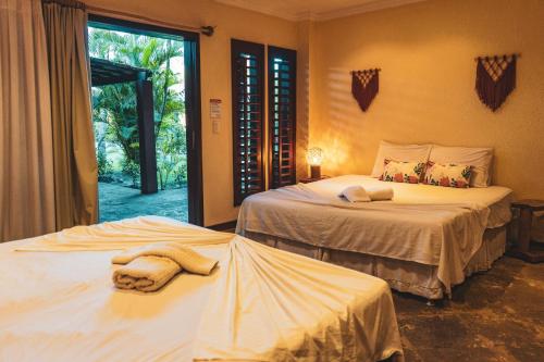 two beds with towels on them in a bedroom at Pousada Meeting Point & KiteSchool in Cumbuco