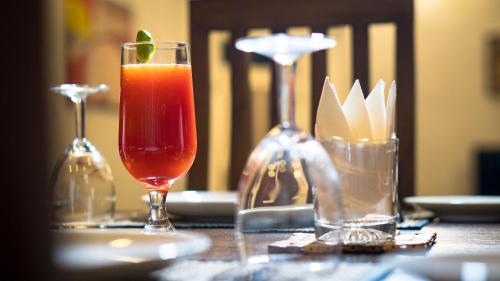una mesa con una bebida y dos vasos en ella en The Rosedale Grand Bungalow Nuwara Eliya en Nuwara Eliya