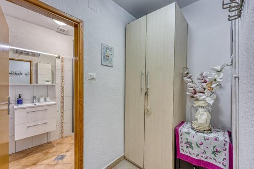 a bathroom with a vase of flowers on a table at Holiday Apartment Stojanovski in Rovinjsko Selo
