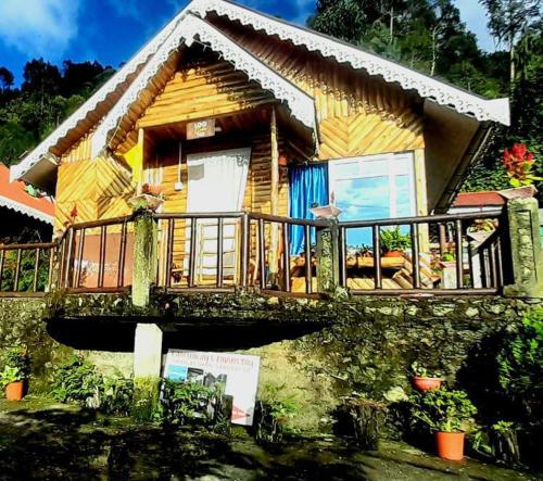 a wooden house with a bridge in front of it at Kapchakays Farmstay by StayApart in Kalimpong