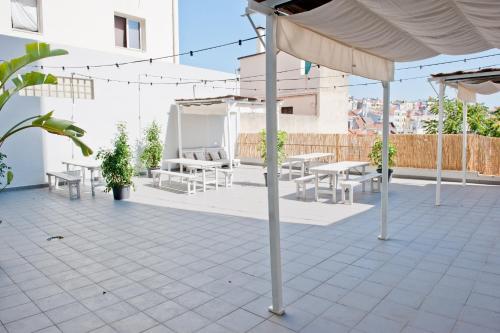 een patio met tafels en stoelen en een parasol bij Garden Pátio 1B - 1 BDR with Terrace in Lissabon