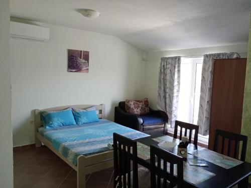 sypialnia z łóżkiem i stołem z krzesłami w obiekcie Apartments Vidikovac w mieście Tivat