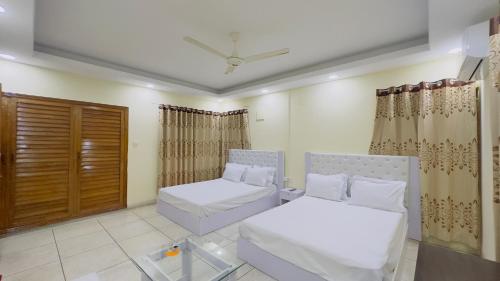a living room with two beds and curtains at Hotel Blue Sky Inn Banani in Dhaka