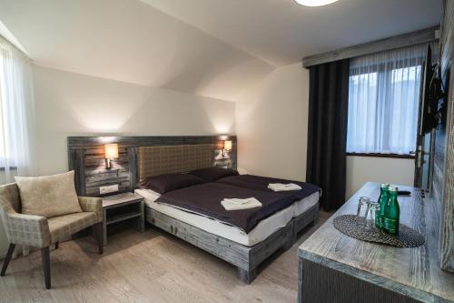 a bedroom with a bed and a desk and a chair at Vila Ambiente Donovaly in Donovaly