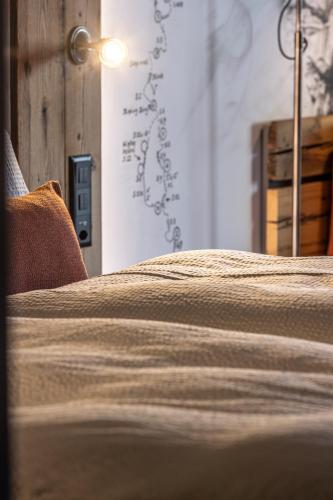 a bedroom with a bed and a wall with writing on it at BaseCamp Hotel in Zermatt