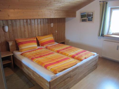 um quarto com uma cama com duas almofadas em Ferienwohnung Enzinger em Teisendorf