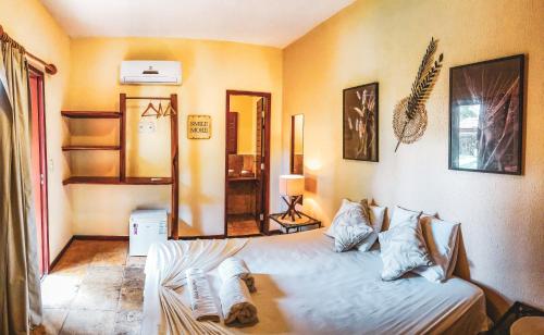 a bedroom with a bed and a mirror on the wall at Pousada Meeting Point & KiteSchool in Cumbuco
