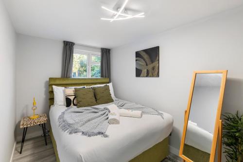 a bedroom with a bed and a mirror at Stunning 2 Bedroom House with Garden BBQ - Hampstead Heath Park in London