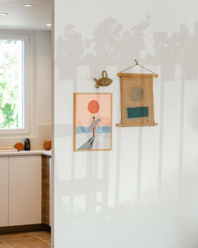 une cuisine dotée d'un mur blanc avec une photo et un oiseau. dans l'établissement SIENNA, appartement 3 chambres en résidence, à Saint-Tropez