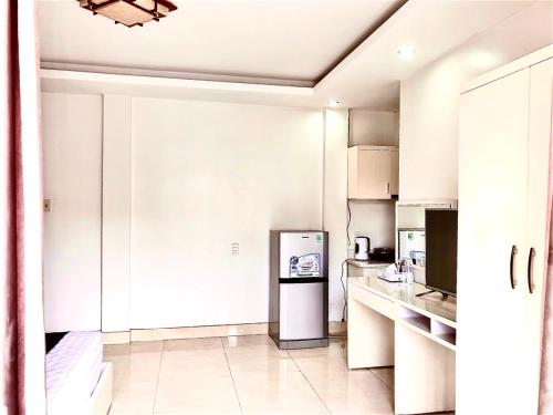 - une cuisine blanche avec un réfrigérateur dans l'établissement Hotel Nam Sơn, à An Khê