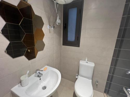a bathroom with a toilet and a sink and a mirror at Studio EL Gouna G-Cribs in Hurghada