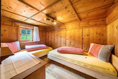 een kamer met 2 bedden in een houten hut bij Ferienhaus Engele in San Martino