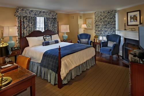 Inn on Boltwood في أميرست: غرفة فندقية بها سرير وموقد