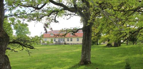 una casa en medio de un campo con árboles en Yxkullsund Säteri B&B - Manor & Estate since 1662, en Lagan