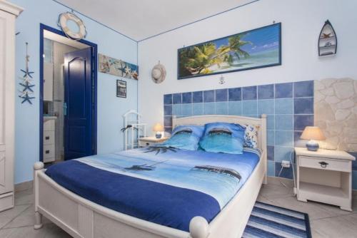 Schlafzimmer mit einem großen Bett und blau gefliesten Wänden in der Unterkunft Villa Jany- Adults only in Oria
