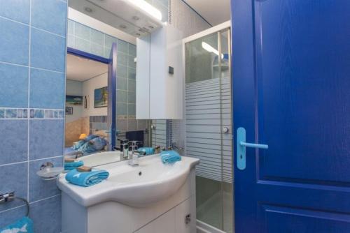 łazienka z umywalką i niebieskimi drzwiami w obiekcie Villa Jany- Adults only w mieście Oria