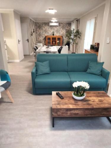 un salon avec un canapé bleu et une table basse dans l'établissement LA FIGUIERA de 1 à 4 personnes, à Lavergne