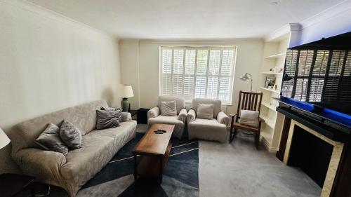 ein Wohnzimmer mit einem Sofa und einem Kamin in der Unterkunft Enchantia Stayz: Central London's Exquisite Abodes in London