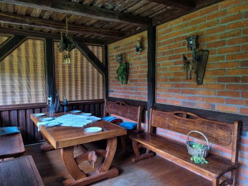 a room with a table and benches and a brick wall at Siedlisko Otulenie in Bartoszyce