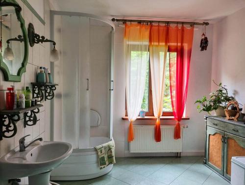 a bathroom with a tub and a shower and a sink at Siedlisko Otulenie in Bartoszyce