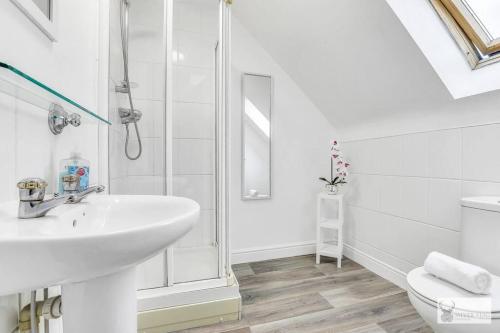 a white bathroom with a sink and a toilet at Silver Stag Properties, 4 BR Gem in Coalville in Coalville