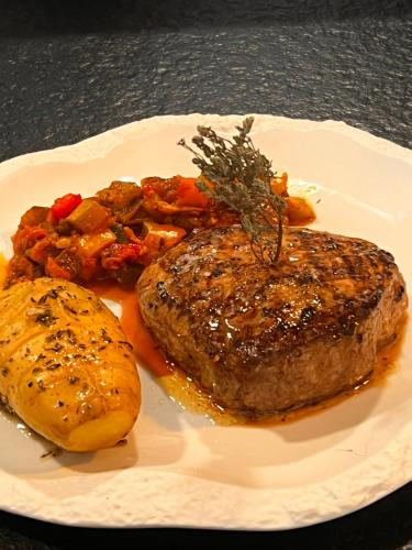 a plate of food with meat and vegetables on a table at LA VILLA in Terraube