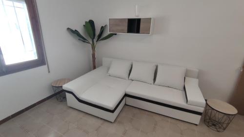 een witte bank in een woonkamer met een plant bij Diamante en Cambrils Costa Dorada in Cambrils