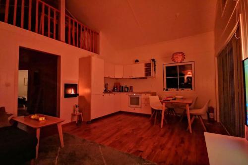 a living room with a table and a kitchen at Lovely home by Glomma river! in Vidnes