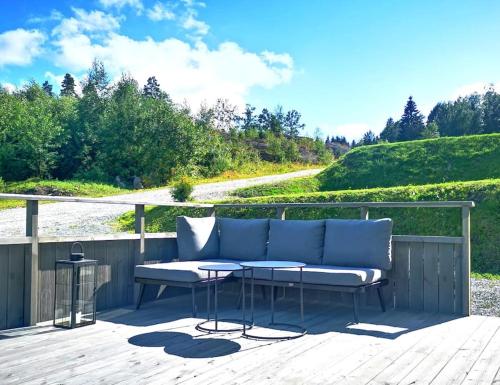 a patio with a bench and a table on a deck at Lovely home by Glomma river! in Vidnes