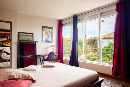 a bedroom with a bed and a large window at Dolce Vita in La Ciotat