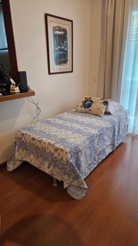 um quarto com uma cama com um cobertor em Flat - Apart-hotel em Belo Horizonte