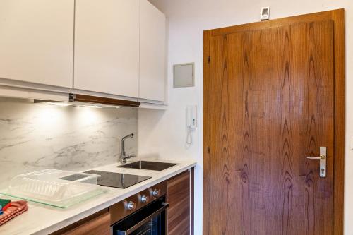 a kitchen with a sink and a wooden door at Haus Excelsior Top 17 in Seefeld in Tirol
