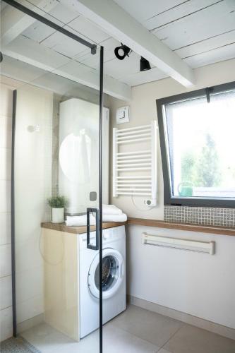 a laundry room with a washing machine and a window at Gîte Le Carpe diem Milly-la-Forêt in Milly-la-Forêt