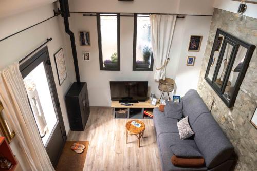 a living room with a blue couch and a tv at Gîte Le Carpe diem Milly-la-Forêt in Milly-la-Forêt