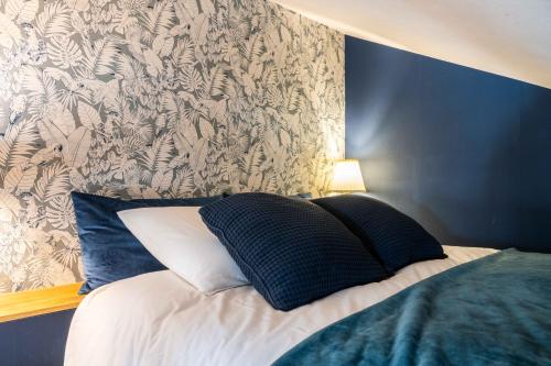- une chambre dotée d'un lit avec un mur bleu dans l'établissement Gîte Le Carpe diem Milly-la-Forêt, à Milly-la-Forêt