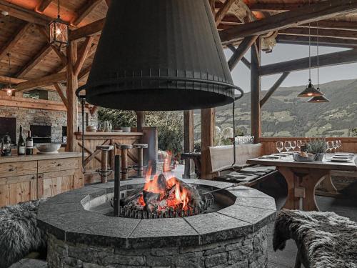 a fireplace in a living room with a fire pit at ASTER Boutique Hotel & Chalets in Fügenberg