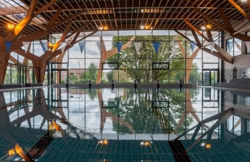 une piscine vide dans un grand bâtiment avec fenêtres dans l'établissement Gîte Le Carpe diem Milly-la-Forêt, à Milly-la-Forêt
