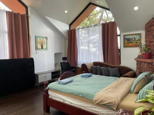 a bedroom with a bed and a large window at Country Homes Sheridan Drive Camp John Hay Lot 16 in Baguio