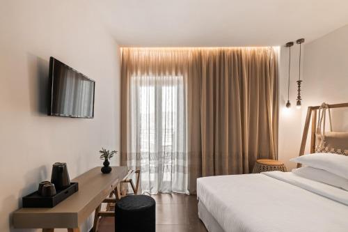 a hotel room with a bed and a desk and a window at Kera Neme in Neméa
