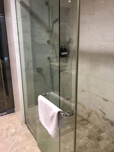 a shower with a white towel on a glass door at KLCC Sky Villa Suites Platinum in Kuala Lumpur